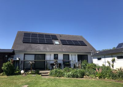 Eine Photovoltaikanlage auf der anderen Dachseite eines Hauses, die Solarenergie in Strom umwandelt.